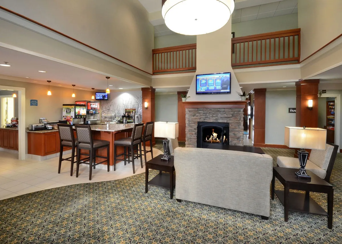 A stylish interior lounge with a cozy fireplace, comfortable seating areas, a bar counter, and warm decorative lighting. The atmosphere is both inviting and relaxing, ideal for unwinding after a busy day.
